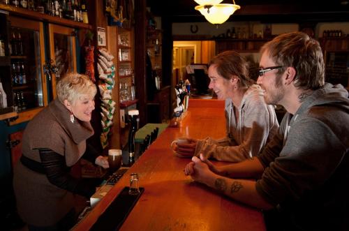a group of people standing at a bar at Heriot Bay Inn in Heriot Bay