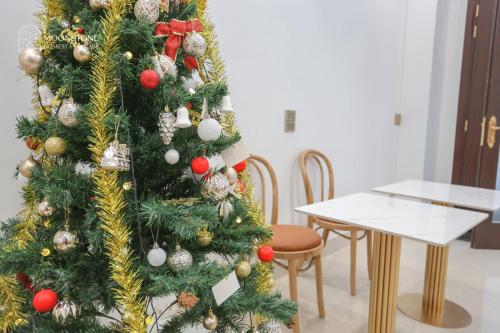 a christmas tree in a room with a table at Moonstone Homestay & Cafe - Vinhomes Ocean Park 2 in Hòa Bình