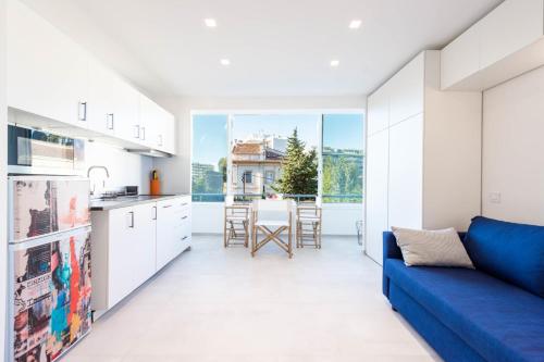 Il comprend une cuisine et un salon doté d'un canapé bleu. dans l'établissement 1-Br Apartment Quiet Area near Cannes Center, à Cannes