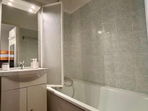 La salle de bains est pourvue d'une baignoire blanche, d'un lavabo et d'une baignoire. dans l'établissement Studio cabine lumineux avec piscine à 400m de la plage - 4 couchages - FR-1-225-822, à Argelès-sur-Mer