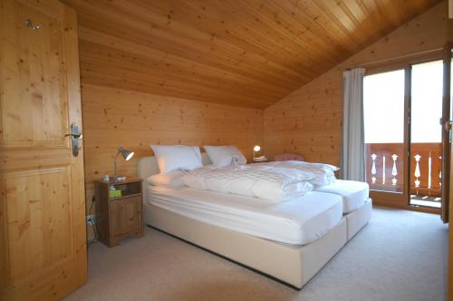a bedroom with a bed in a wooden room at Chalet la Murier in Leysin