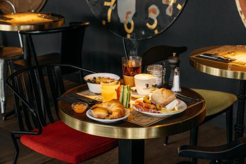 a table with a tray of breakfast food on it at Ruby Claire Hotel Geneva in Geneva
