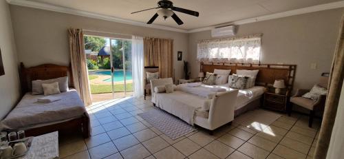 a bedroom with a bed and a couch and a window at Tamboti Bush Lodge in Dinokeng Game Reserve
