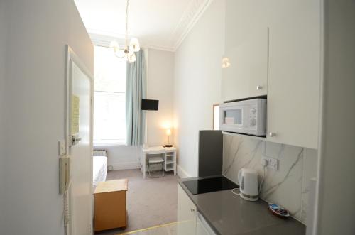 a room with a kitchen with a microwave at Amber Residence Hotel-Suites in London