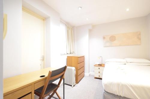 a bedroom with a desk and a bed and a desk and chair at Amber Residence Hotel-Suites in London