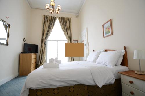a bedroom with a large white bed with a window at Amber Residence Hotel-Suites in London