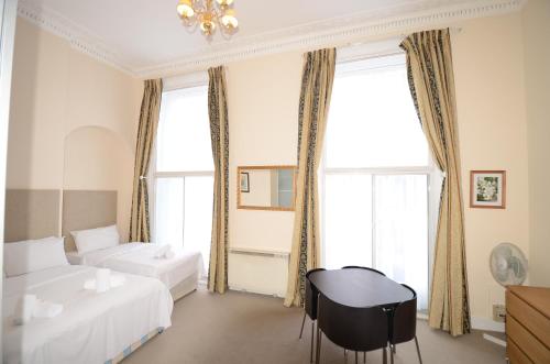 a hotel room with two beds and a table at Amber Residence Hotel-Suites in London