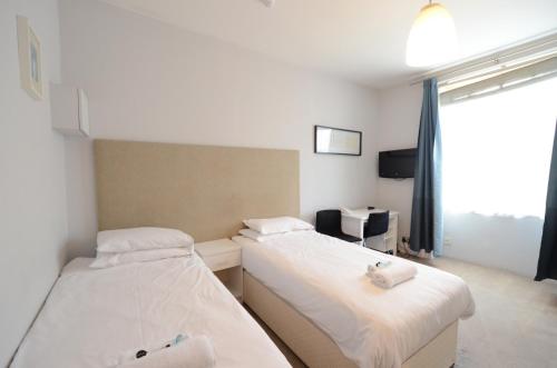 two beds in a room with a window at Amber Residence Hotel-Suites in London