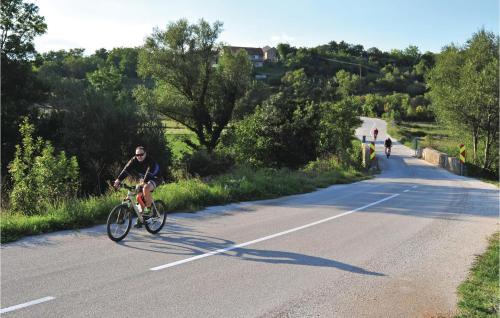 a man riding a bike down a road at Holiday Home Vojnic Sinjski 11 in Vojnić Sinjski