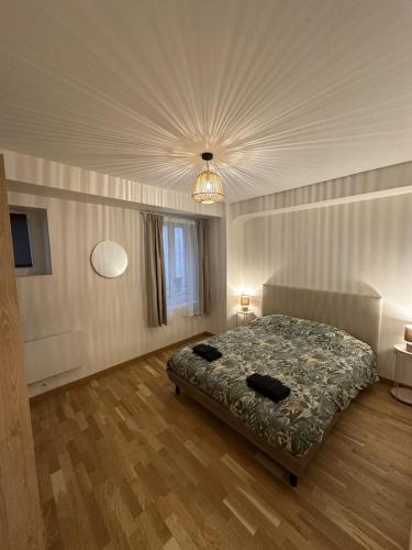 une chambre avec un lit et un lustre dans l'établissement L'escapade du Gros Horloge, à Rouen