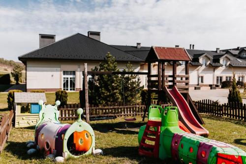 a group of playground equipment in front of a house at Dosłońce Resort Wellness & Farm in Racławice