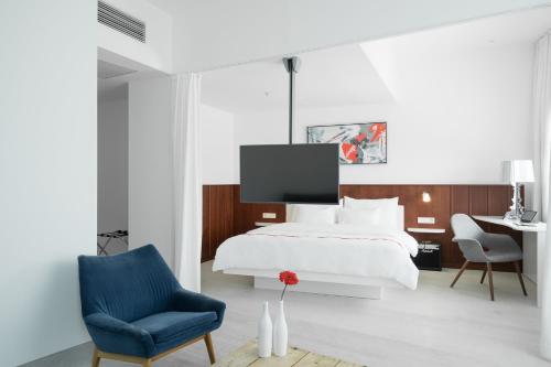a bedroom with a white bed and a blue chair at Ruby Marie Hotel Vienna in Vienna