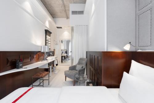 フランクフルト・アム・マインにあるRuby Louise Hotel Frankfurtのベッド、デスク、椅子が備わるホテルルームです。