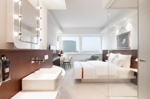 a hotel room with a bed and a bathroom at Ruby Luna Hotel Dusseldorf in Düsseldorf
