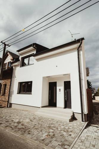 a white house with a garage at Hotel U Racka in Ostrožská Nová Ves