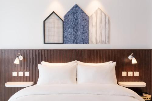 a bedroom with a large bed with white pillows at Ruby Zoe Hotel London in London