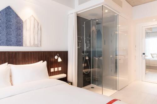 una camera da letto con doccia in vetro e un letto di Ruby Zoe Hotel London a Londra
