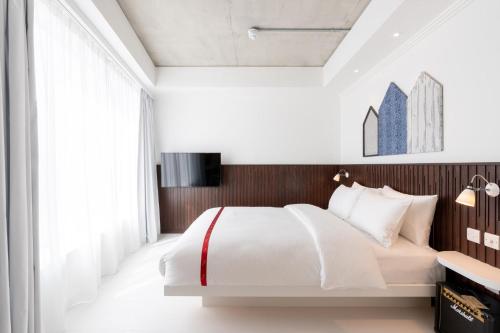 a bedroom with a white bed and a large window at Ruby Zoe Hotel London in London