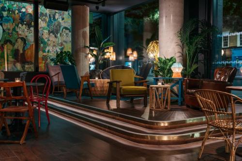 a restaurant with colorful chairs and tables at Ruby Zoe Hotel London in London