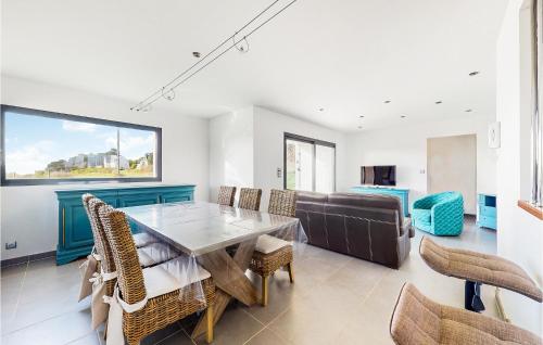 une salle à manger avec une table, des chaises et un canapé dans l'établissement Amazing Apartment In Planguenoual, à Planguenoual
