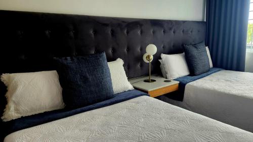 a bedroom with two beds with blue and white pillows at The Bay View Hotel in Richards Bay