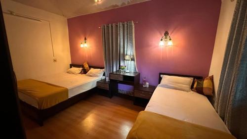 a room with two beds and a window at Little Bricks Reverside Villa by GreenEscapes in Vythiri