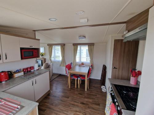 a kitchen and dining room with a table and chairs at Durdlee Door, D27, Main Rd, West Lulworth, Wareham BH20 5PU in West Lulworth