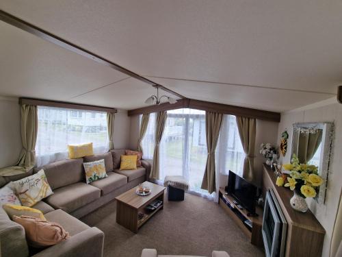 a living room with a couch and a tv at Durdlee Door, D27, Main Rd, West Lulworth, Wareham BH20 5PU in West Lulworth
