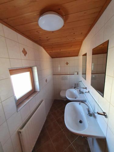 a bathroom with two sinks and a window at Zillertaler Sennhuette in Hart im Zillertal