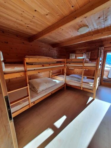 a room with three bunk beds in a cabin at Zillertaler Sennhuette in Hart im Zillertal