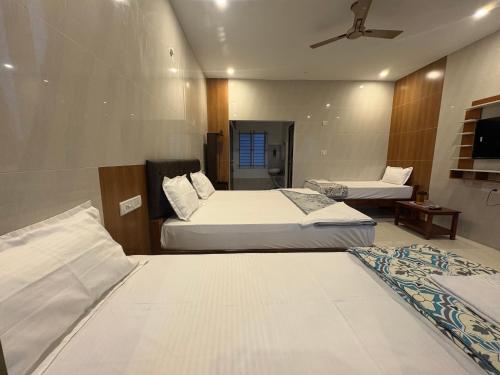 a hotel room with two beds and a ceiling fan at Chill Breeze Paradise in Yelagiri