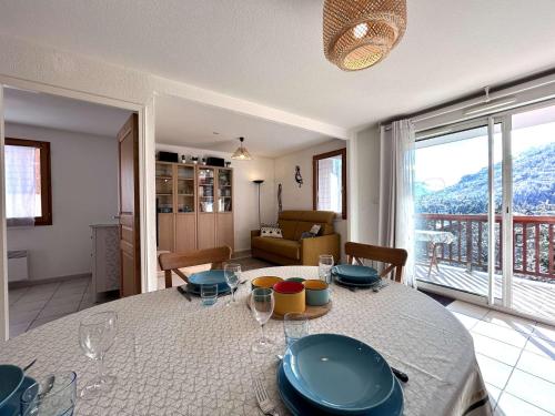 - un salon doté d'une table avec des assiettes et des verres à vin dans l'établissement Appartement 3 étoiles, 3 pièces, 6 pers, terrasse, garage - Briançon - FR-1-330C-69, à Briançon