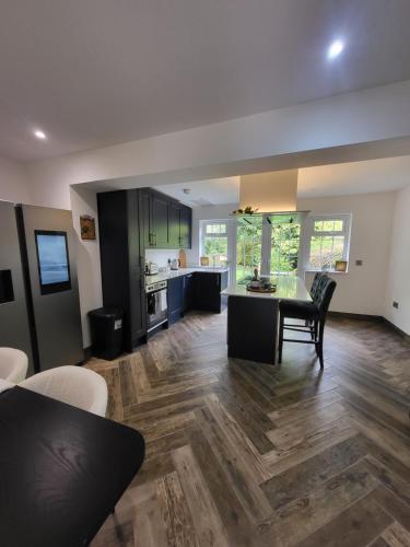 a kitchen and living room with a table and chairs at Parkgate Charming Cottage in Chelsfield