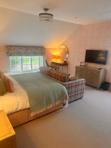 a bedroom with a large bed and a television at Dewars Restaurant and Rooms in Malton
