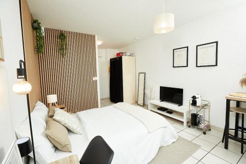 une chambre avec un lit blanc et une télévision dans l'établissement Le Chic Urbain - Hôpitaux Facultés - Chateau d'Ô - Free Parking, à Montpellier