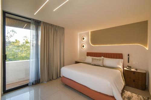 a bedroom with a large bed and a large window at Expo Satelite 2750 Hotel & Suites in Guadalajara