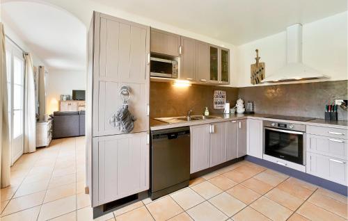 une cuisine avec des armoires blanches et un évier dans l'établissement Beautiful Home In St-Paulet-De-Caisson, à Saint-Paulet-de-Caisson