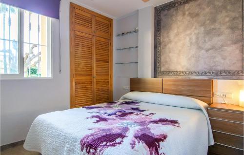 a bedroom with a bed and a painting on the wall at Nice Apartment In Xeraco With Wifi in Xeraco