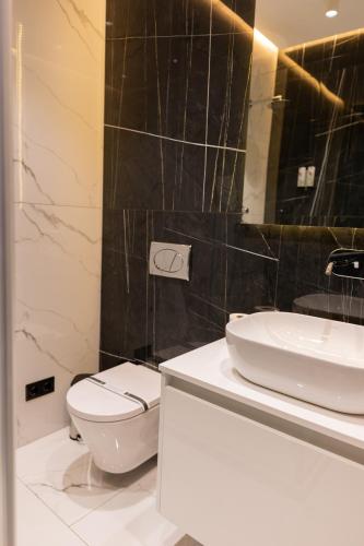 a bathroom with a white toilet and a sink at WHITE HILLS HOTEL spa&sport in Uzhhorod