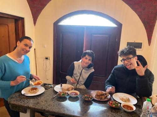 a group of people sitting at a table eating food at Flower of Life Guest house in Cairo