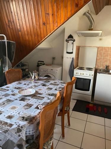 une cuisine avec une table et une cuisinière dans l'établissement Mimimamy, à Drancy