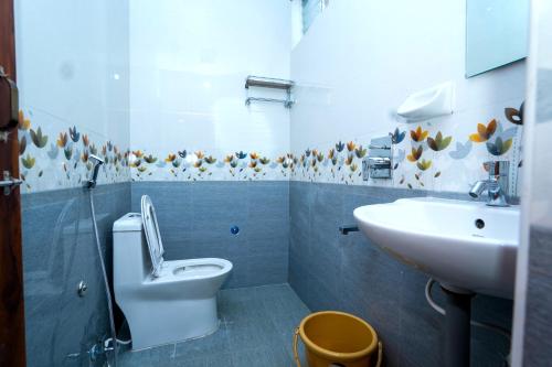 a bathroom with a toilet and a sink at HOTEL THANVI iNN in Guntūr