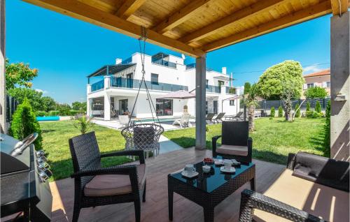 Un patio con sillas y una mesa y una casa. en Pet Friendly Home In Porec, en Poreč