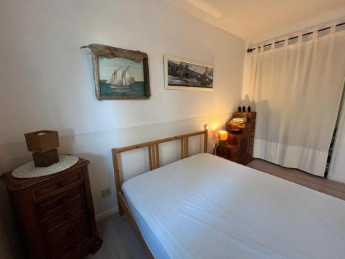 une chambre avec un lit, une commode et une fenêtre dans l'établissement Studio dans belle maison landaise, à Arès