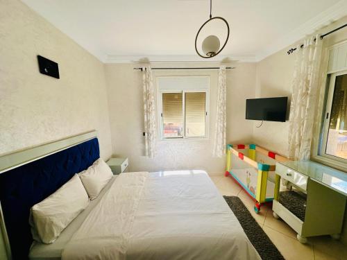 a bedroom with a bed with a blue headboard and a window at Dar La Madina Essaouira in Essaouira
