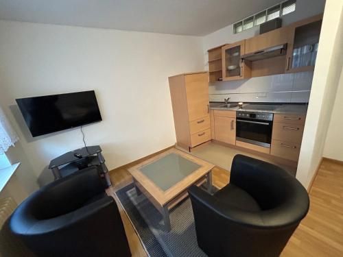 a small living room with two chairs and a television at Gemütliche 1-Zimmerwohnung in der Stadtmitte in Kaiserslautern
