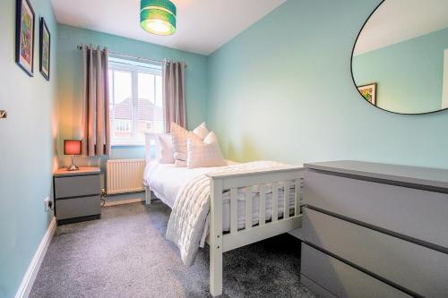 a bedroom with a white bed and a mirror at Grange House - Sleeps 6 - Driveway parking, Self-Check-In, Fast Wifi and Sky TV by Yoko Property in Northampton