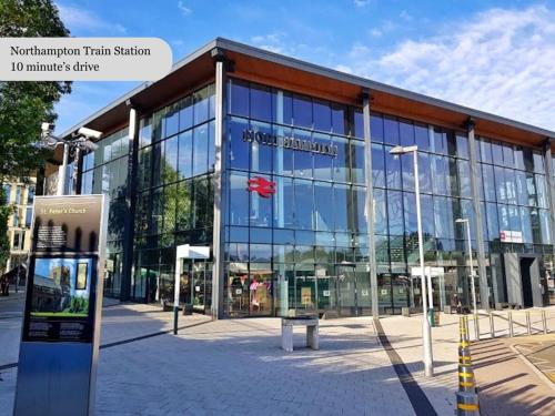 a large glass building with a sign in front of it at Grange House - Sleeps 6 - Driveway parking, Self-Check-In, Fast Wifi and Sky TV by Yoko Property in Northampton