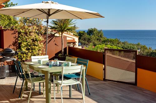 une table et des chaises avec un parasol sur une terrasse dans l'établissement La Terrasse Bleue, à Collioure