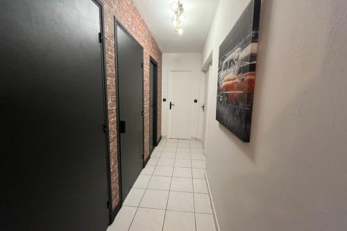 a hallway with a tile floor and a painting on the wall at Spacieux appartement proche des halles Wifi in Narbonne
